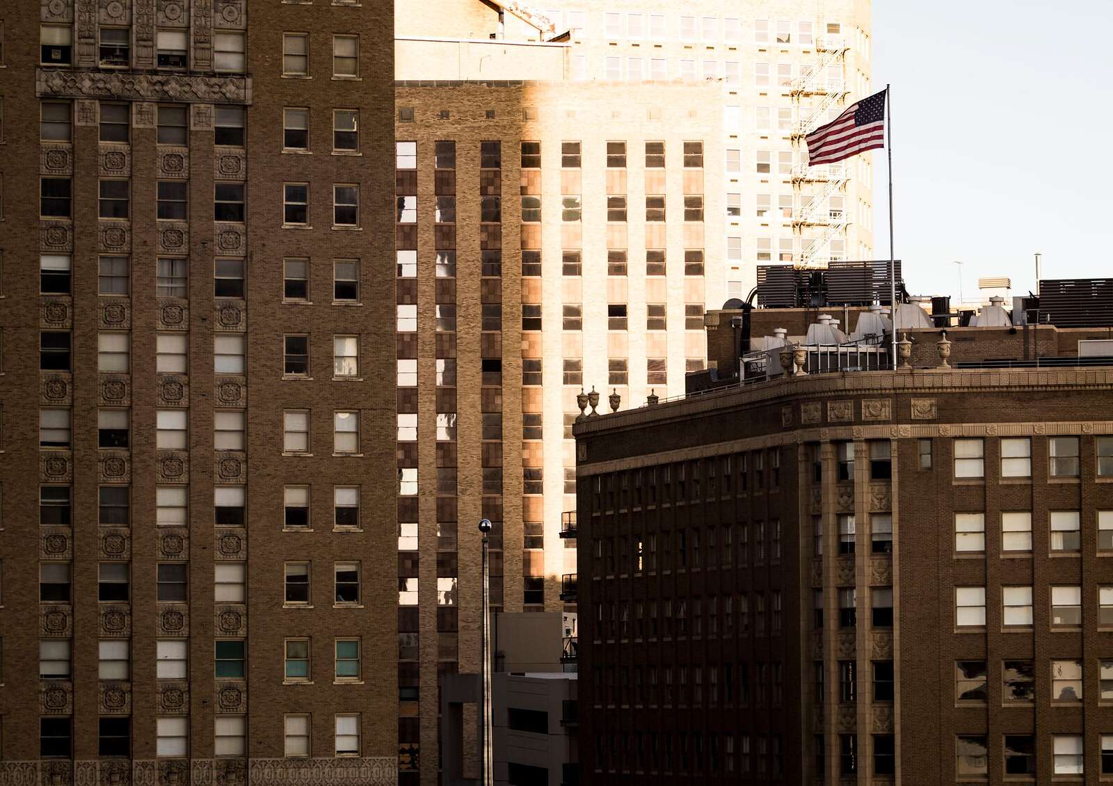 Brick and stone buildings of downtown Fort Worth with an American flag on the skyline