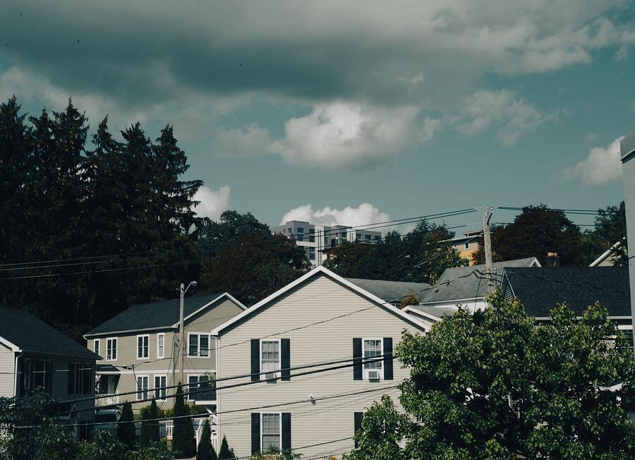 A quiet street of two-story houses under a cloudy sky
